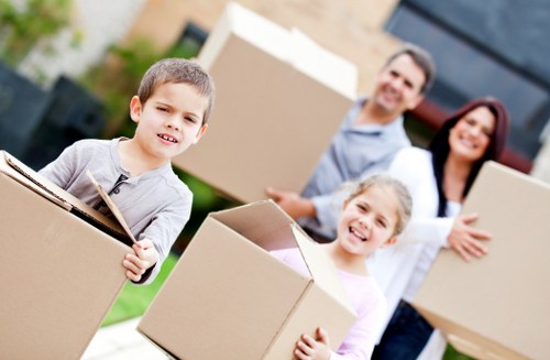 Professional movers transporting furniture through a Sutton property