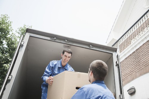 Movers carrying household furniture through a Sutton residential property